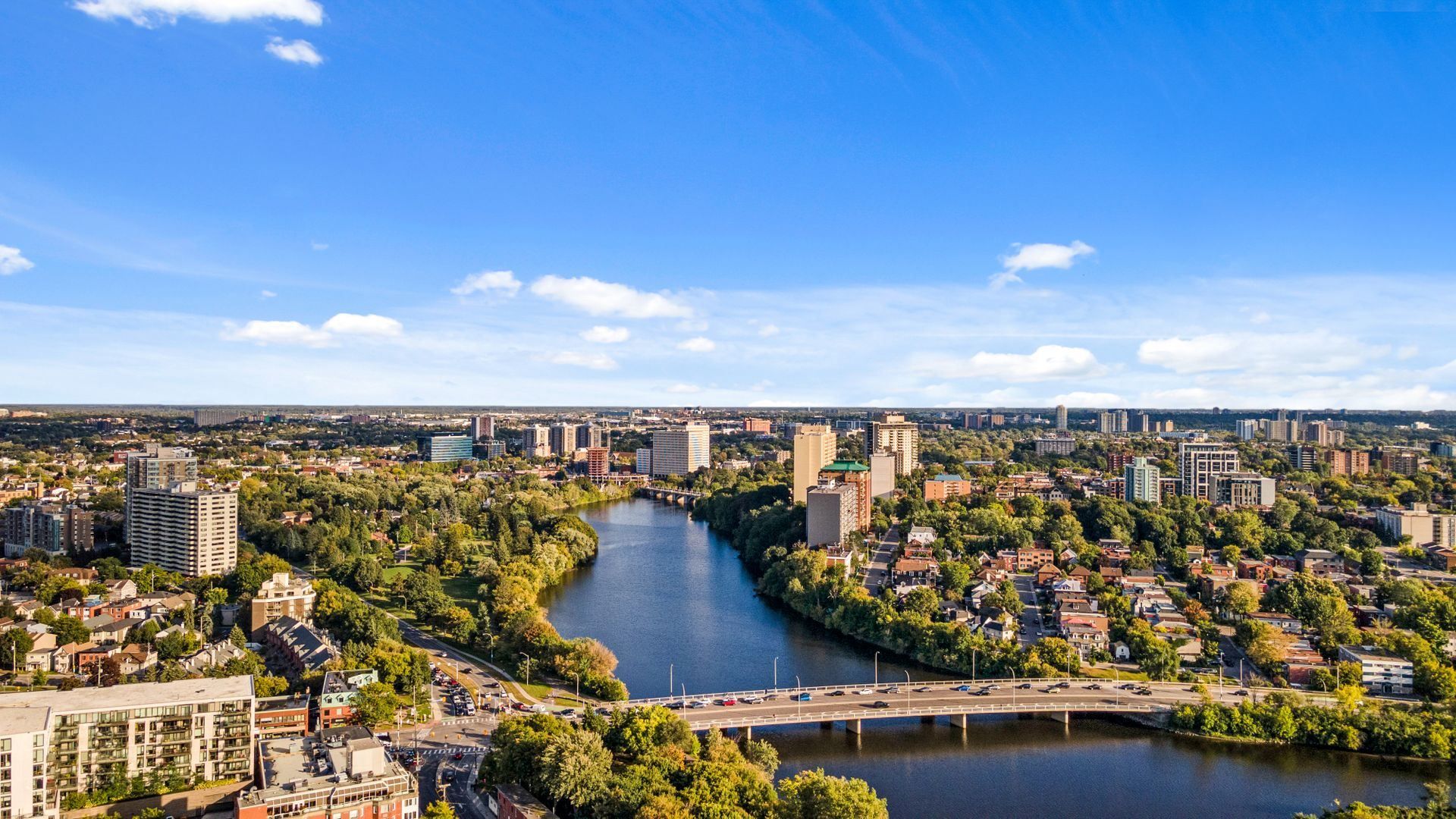 An aerial panorama over the Rideau River and downtown Ottawa under a blue sky