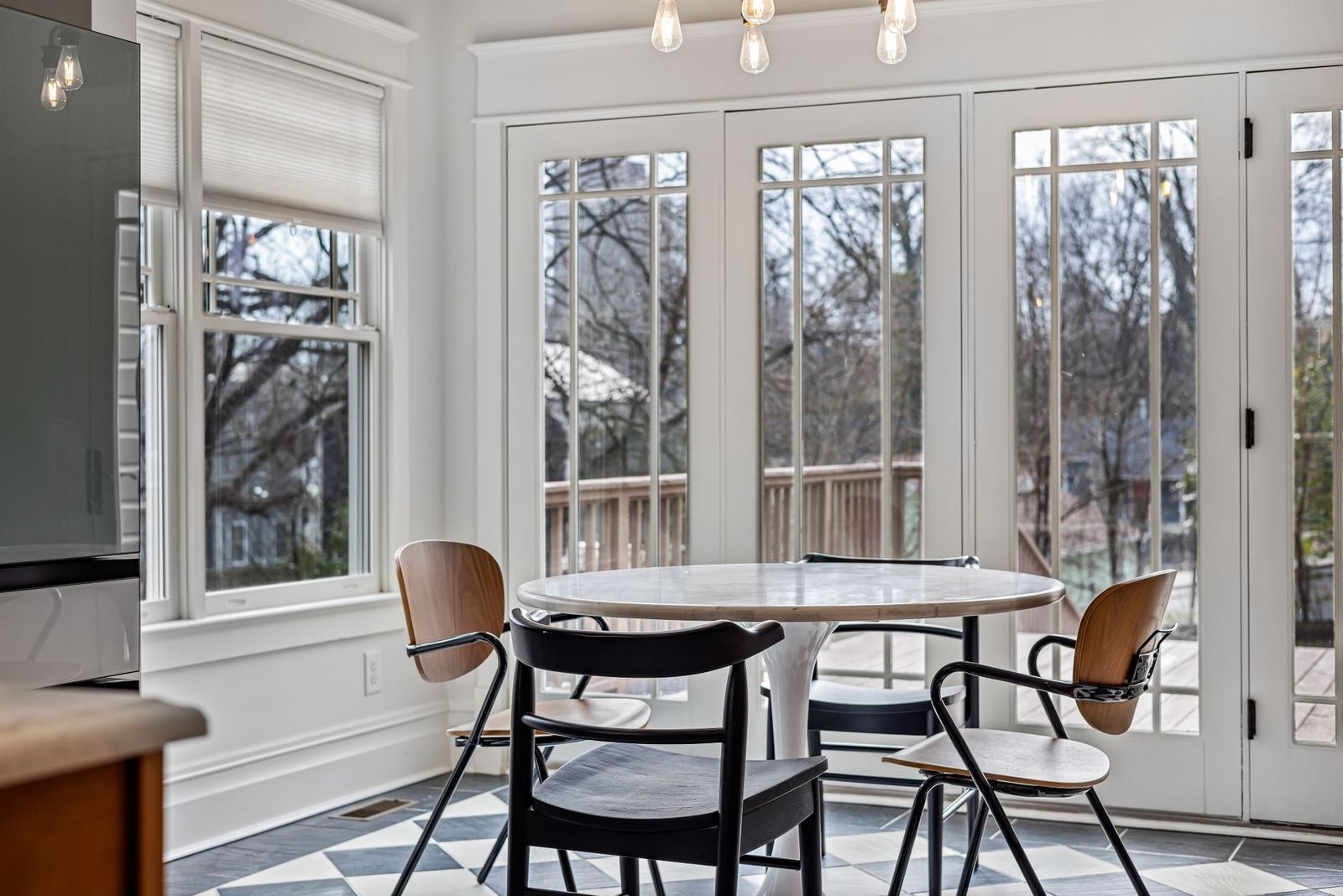 A bright dining area with large windows onto a deck